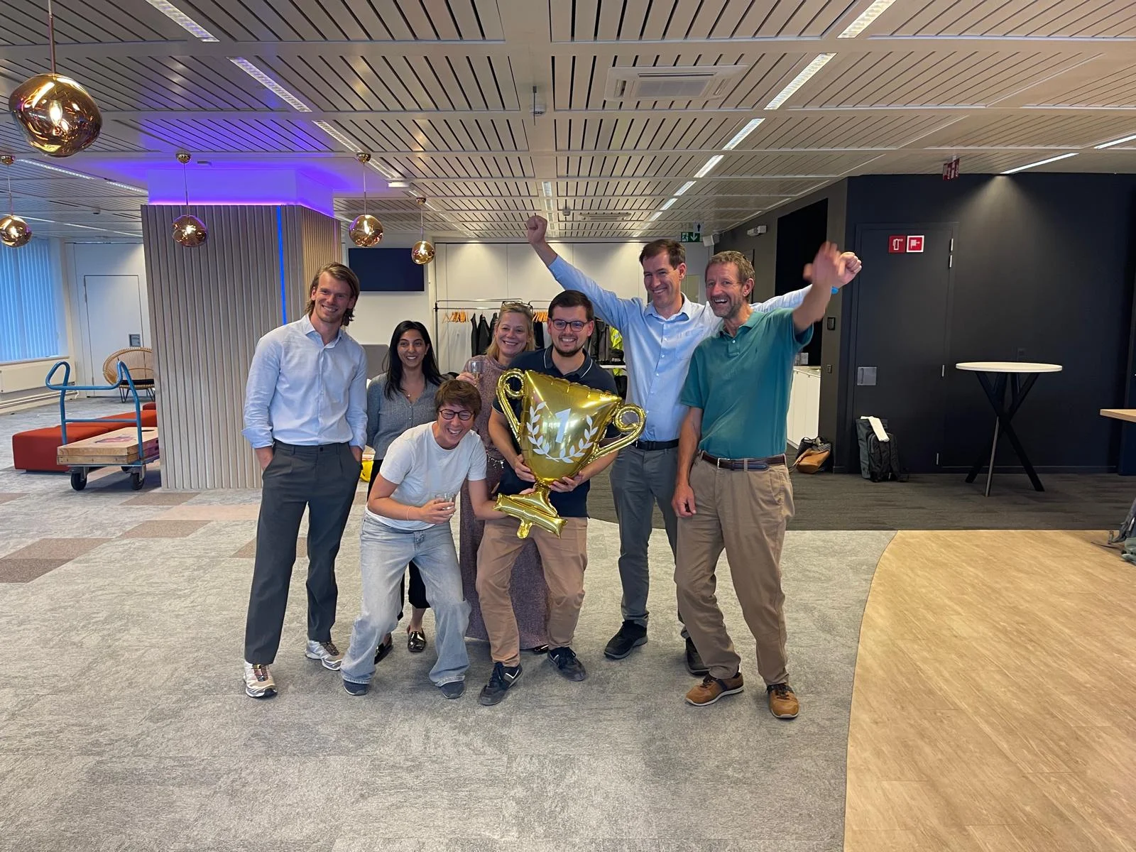 Winnend team viert samen met een gouden trofee